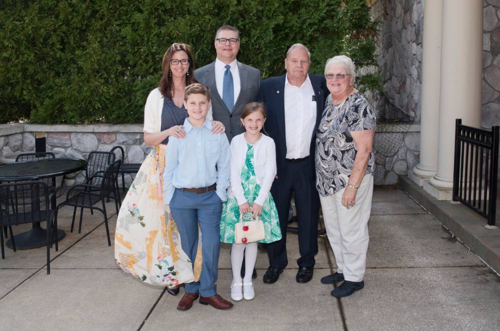 Award winner poses with family (outdoors)